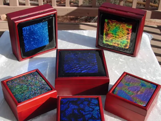 In this picture I can see there are few boxes placed on a white surface and they have decorations...