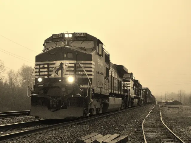 As we can see in the image there is train, railway track, cars, current poles, trees and sky.