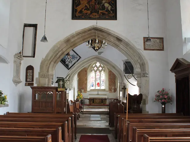 This image might be clicked in a church. There are flower vases in the middle. There are benches at...