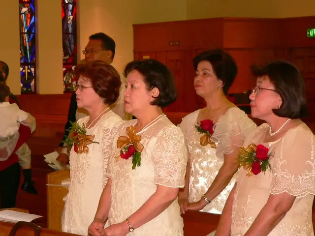 In this image in the middle few women visible and there are some flowers attached to their gown ,...